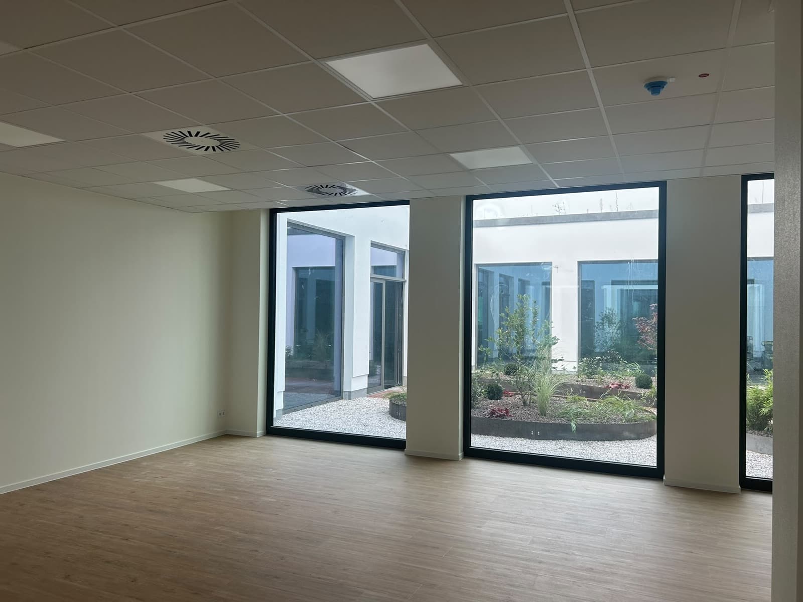 Kursraum mit großer Fensterfront zum begrünten Innenhof